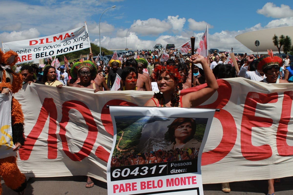 A crowd of indigenous people with banners march the streets in protest of the construction of the Belo Monte dam. 