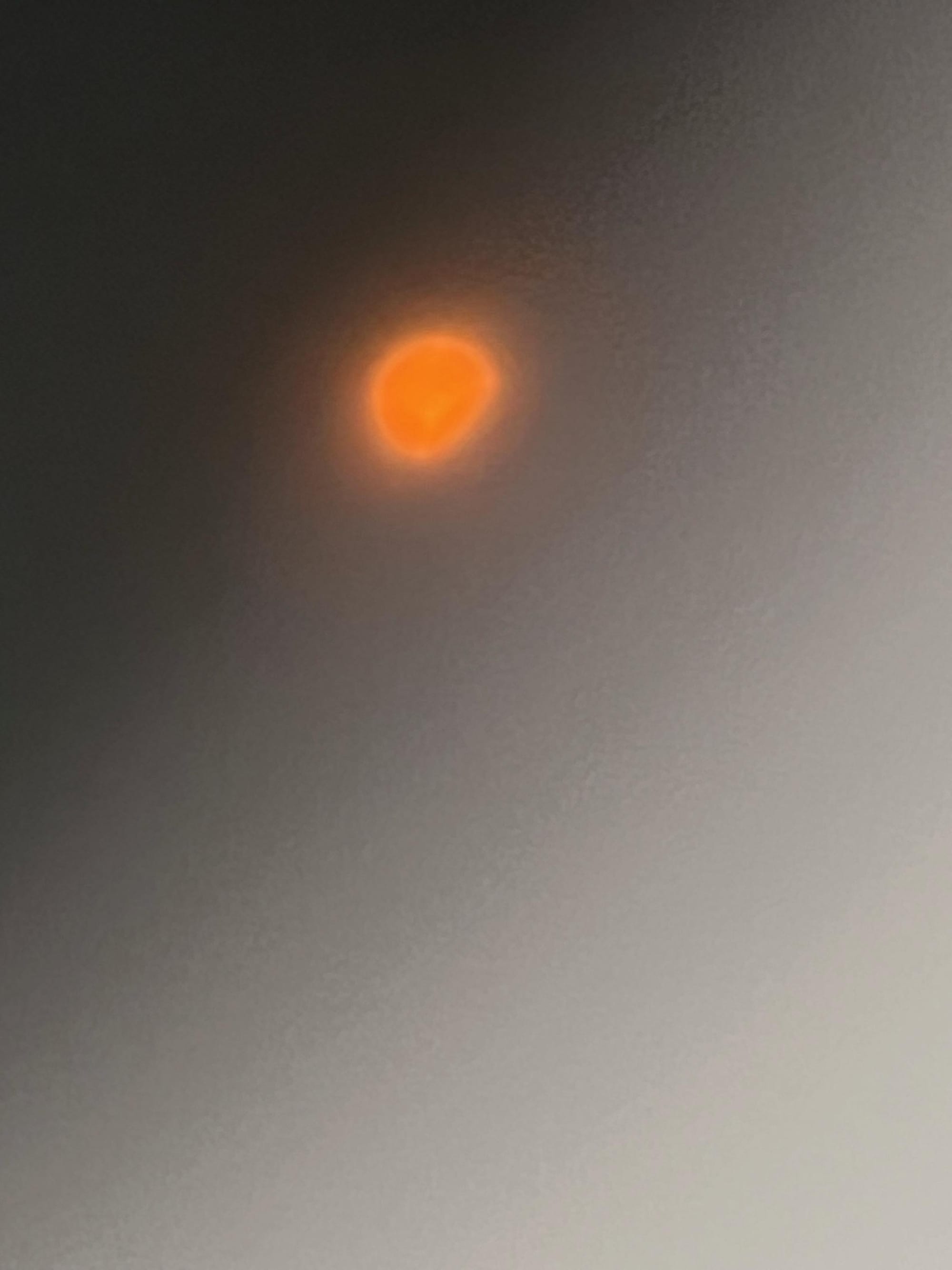 A blurry image of the beginning of the solar eclipse.