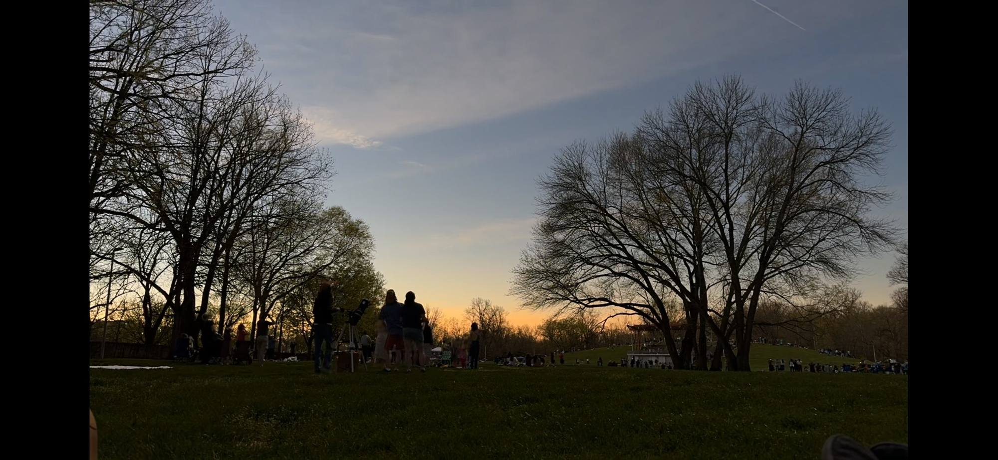 The horizon-wide sunset of the solar eclipse seen from a park