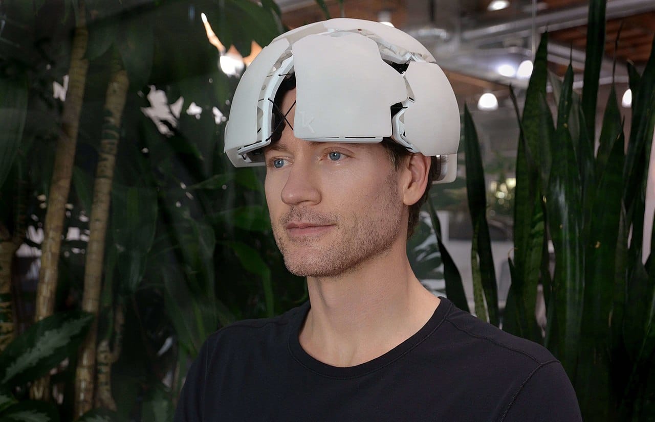 A man wearing a silly looking helmet that looks like half a soccer ball.