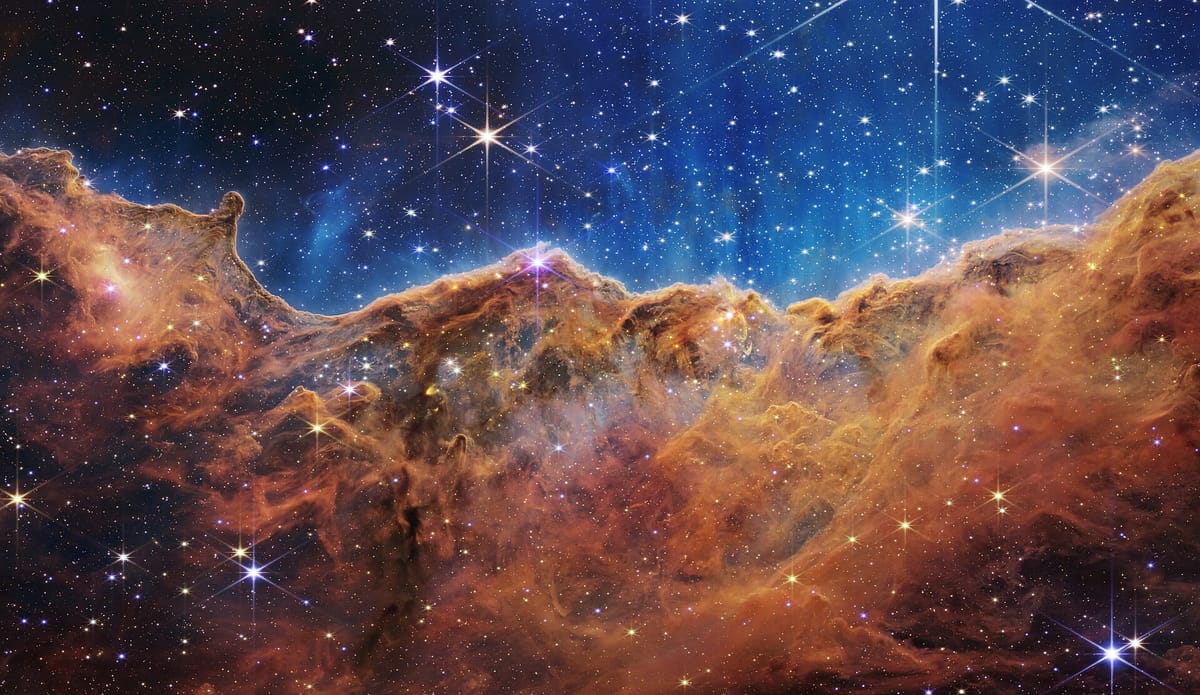 A brown-red nebula dotted with twinkling stars