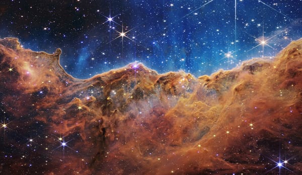 A brown-red nebula dotted with twinkling stars